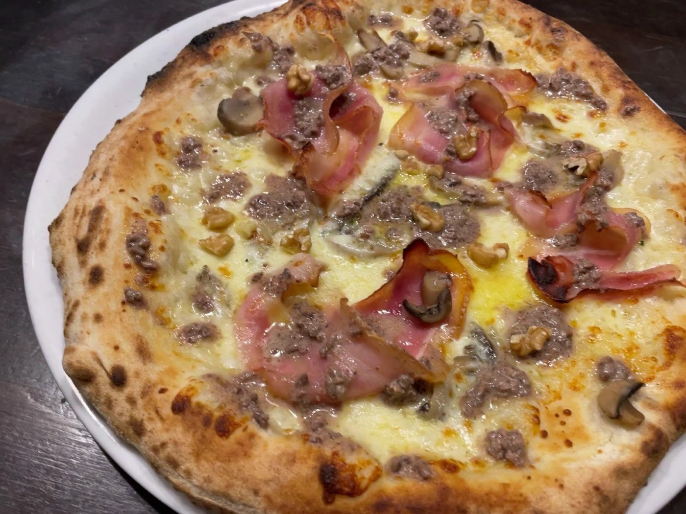 Pizza bianca con speck, salsiccia, funghi e noci